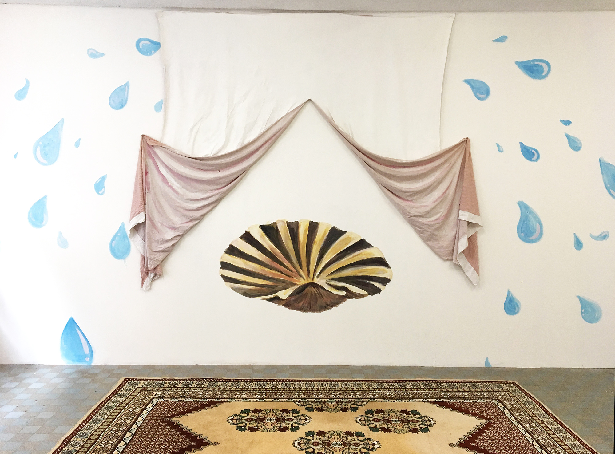 Sur un mur, une peinture d'un coquillage (le même que sur la peinture de la naissance de Venus de Botticelli) est entourée d'un drap repeint en rose depuis le quel des grosses gouttes d'eau en peinture s'échappent. Un tapis persan est posé devant le mur