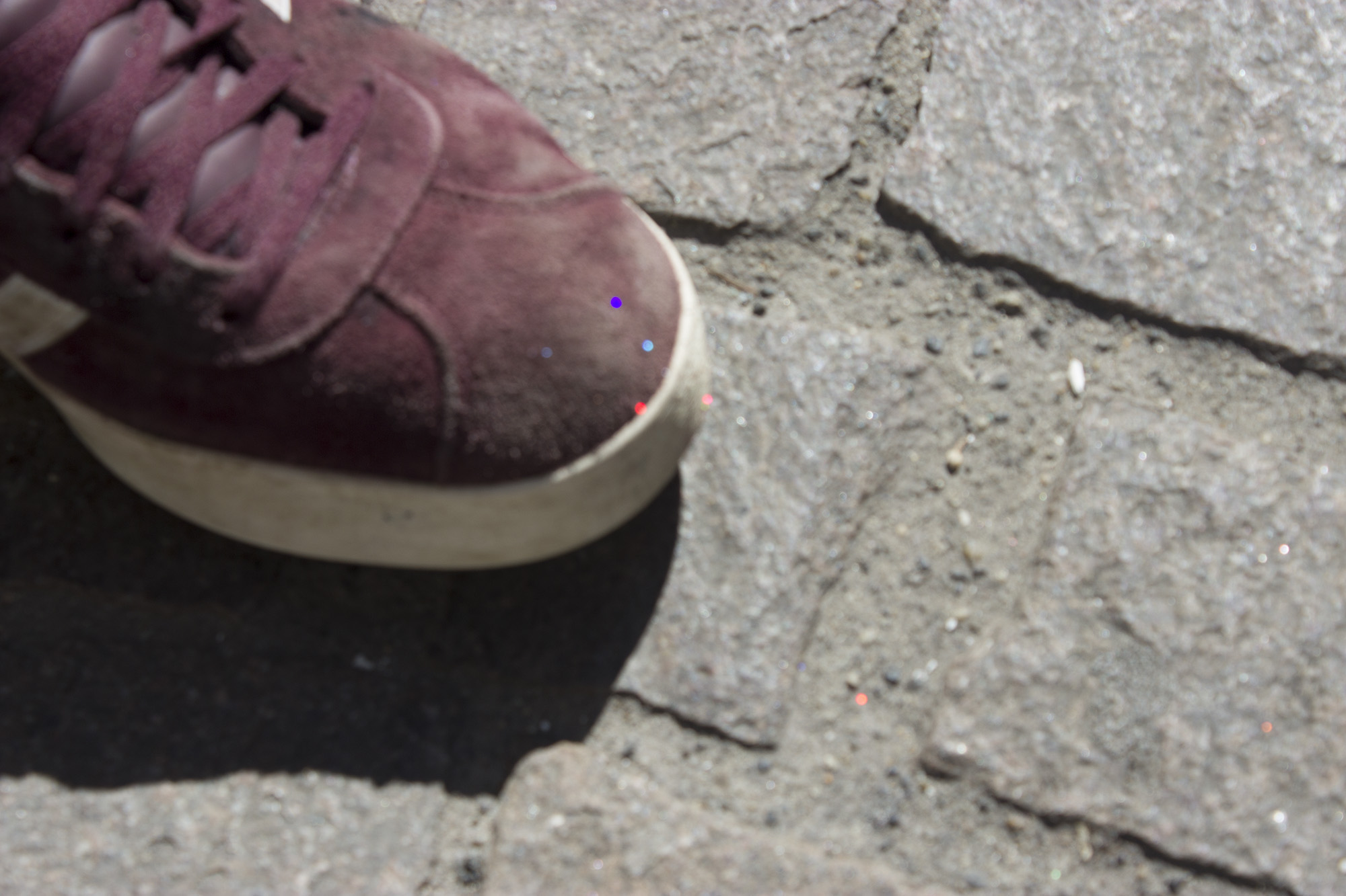 Une chaussure est recouverte de paillettes. Il a dû s'assuyer les pieds avec le paillasson.