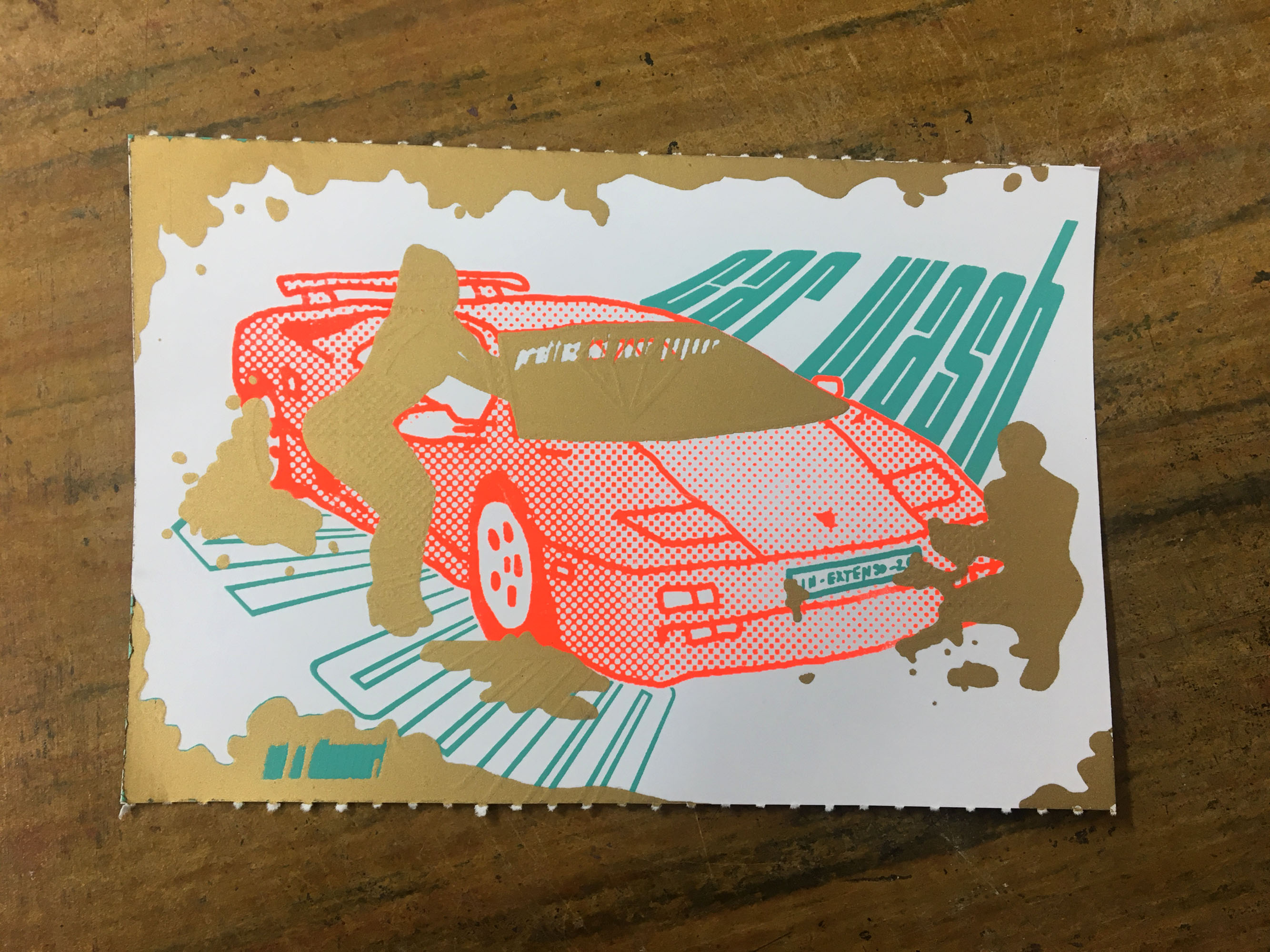 un gros plan sur un ticket à gratter représentant une Lamborghini Diablo rouge fluo recouverte en partie de taches dorées, y compris sur le parbrise et entourée de deux personnes en position sexy. On peut voir qu'il y a inscrit in extenso... sur la plaque d'immaticulation et que dans le fond il y a les mots carwash et vroum en bleu turquoise.